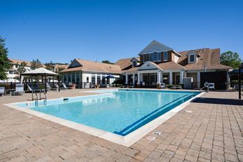 A large swimming pool in front of a house.